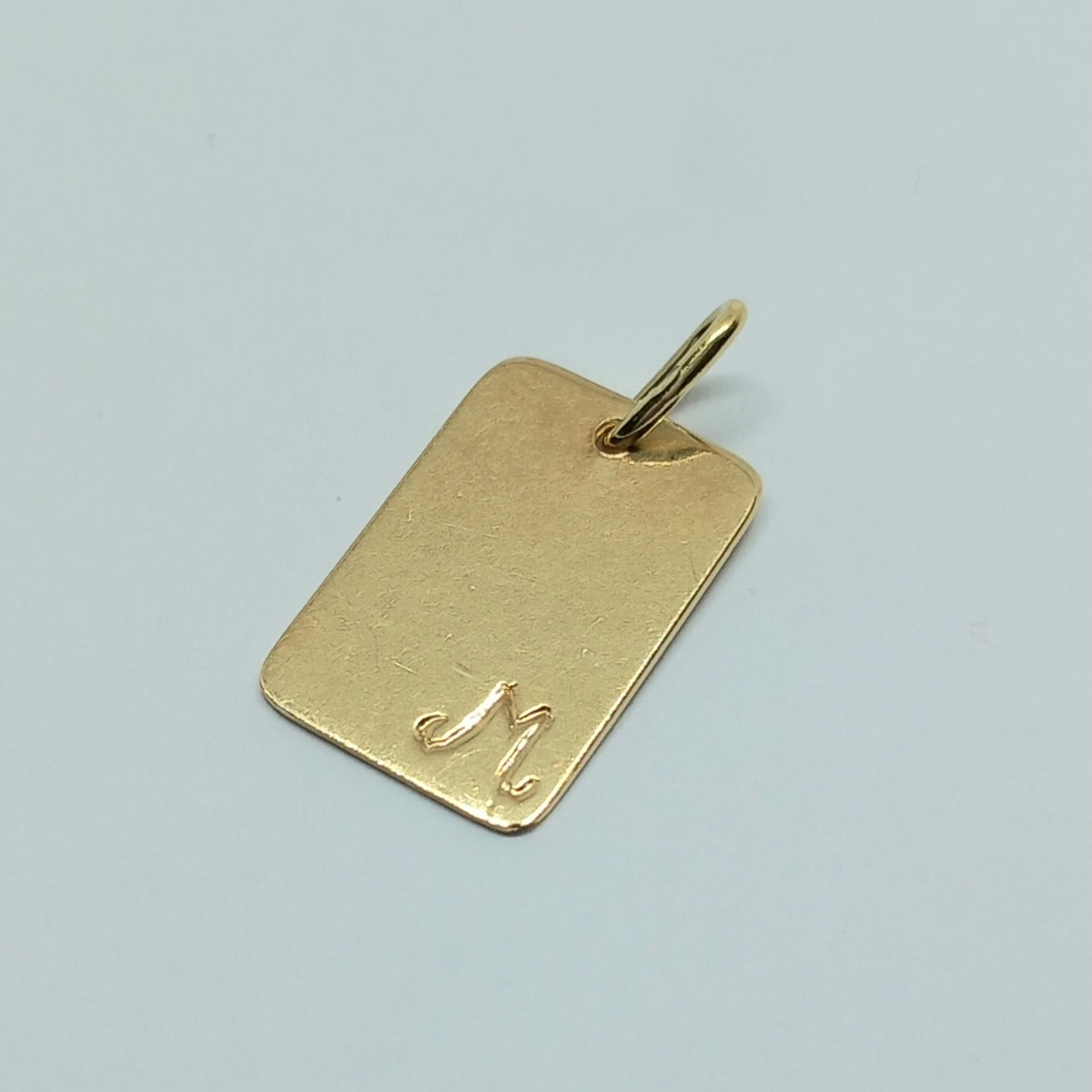 Zlatý přívěšek písmeno M